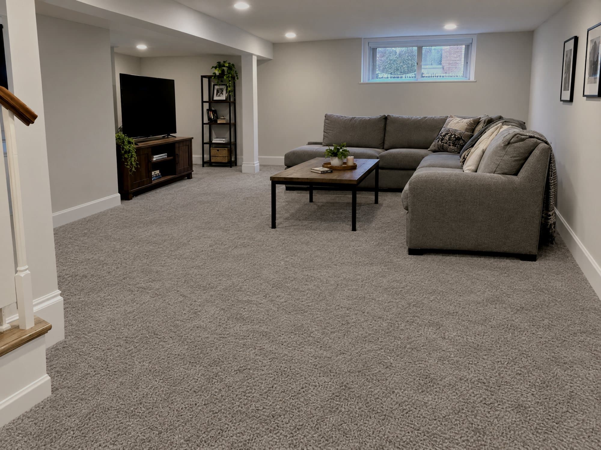 The same basement rebuilt: new carpet, new lower drywall and baseboards, fully dry